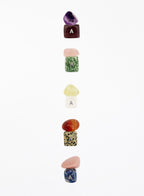 Set of colorful stone-shaped letter 'A' charms on a white background