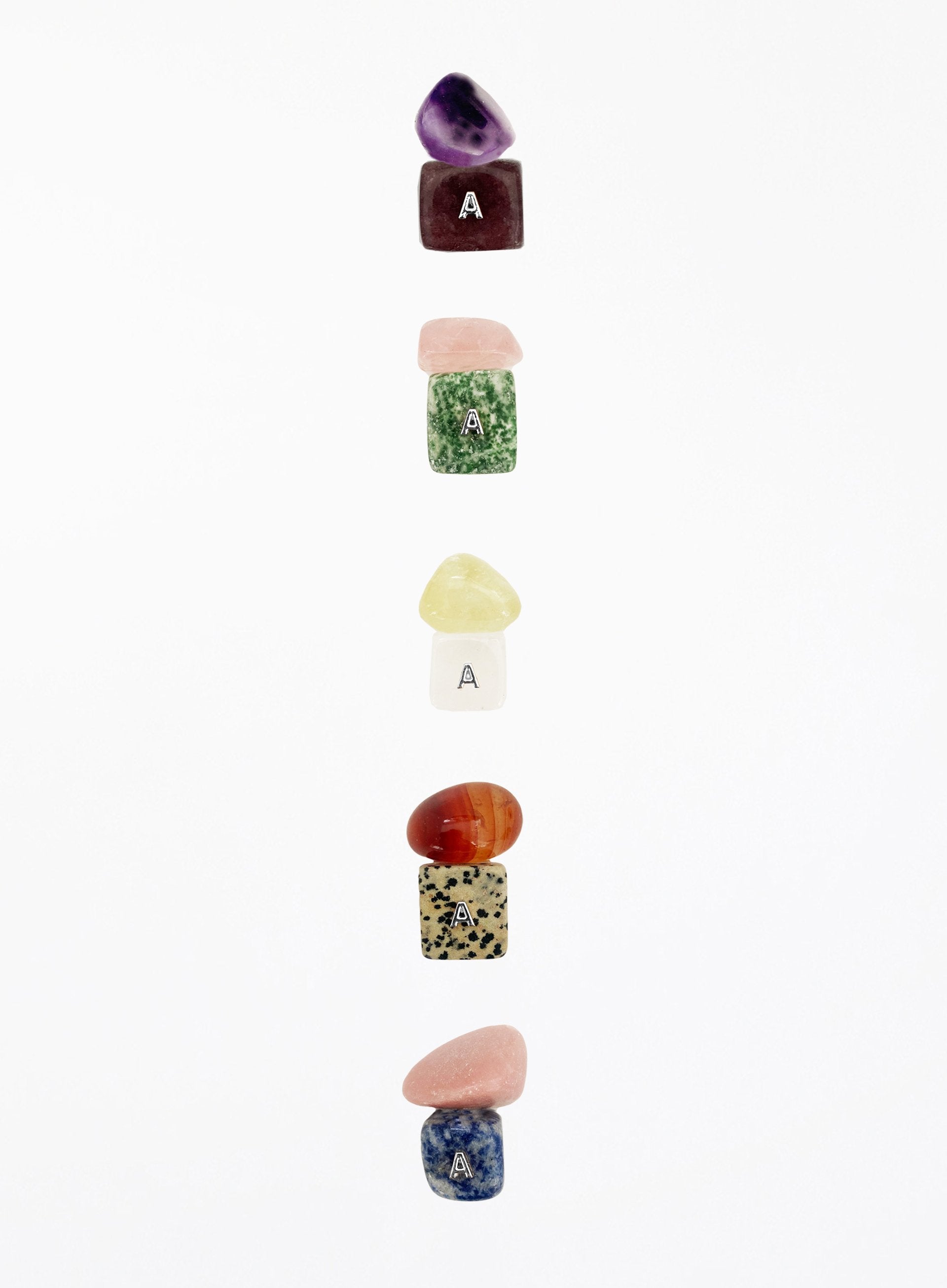 Set of colorful stone-shaped letter 'A' charms on a white background