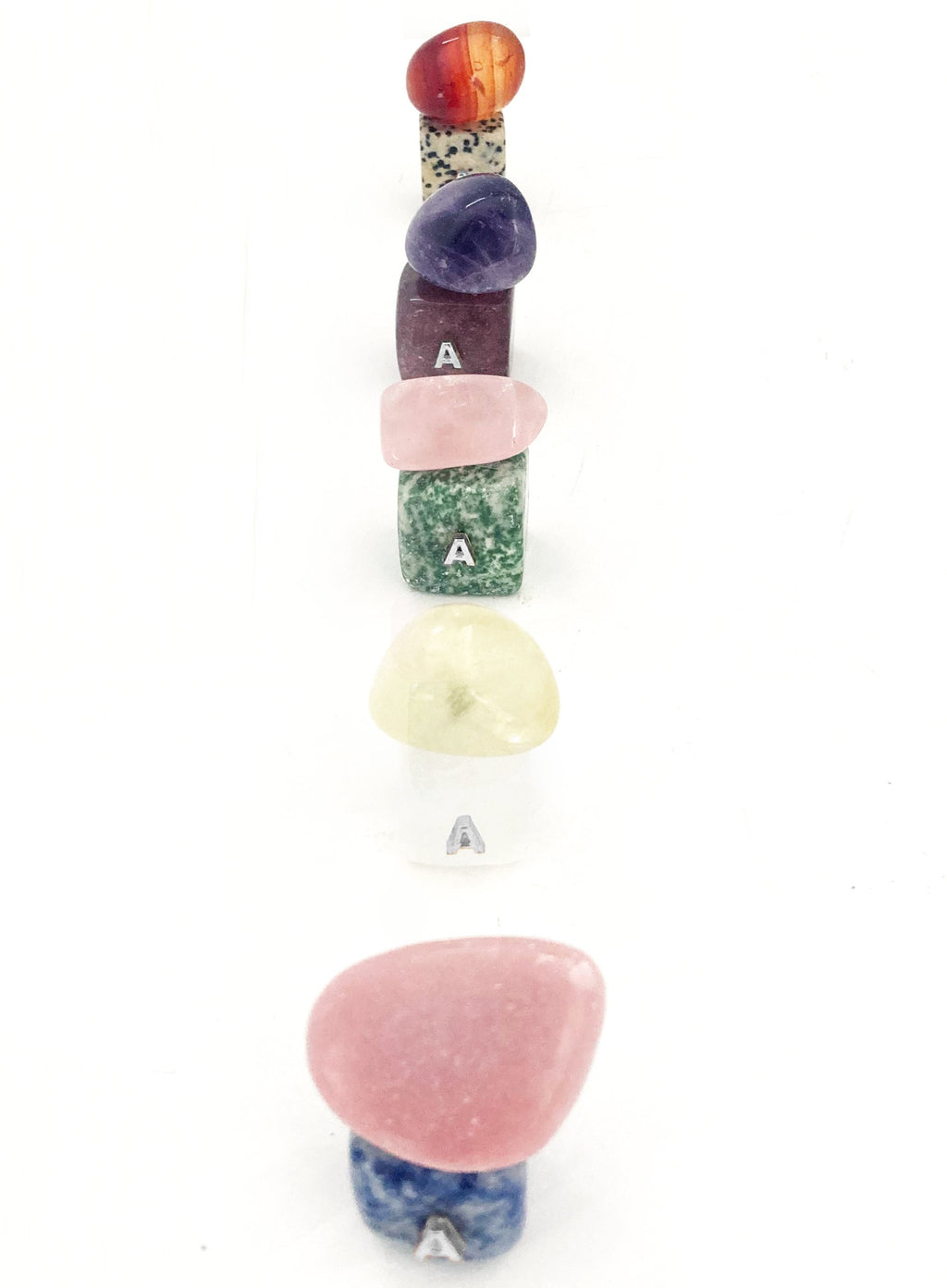 Set of colorful stone-shaped letter 'A' charms on a white background