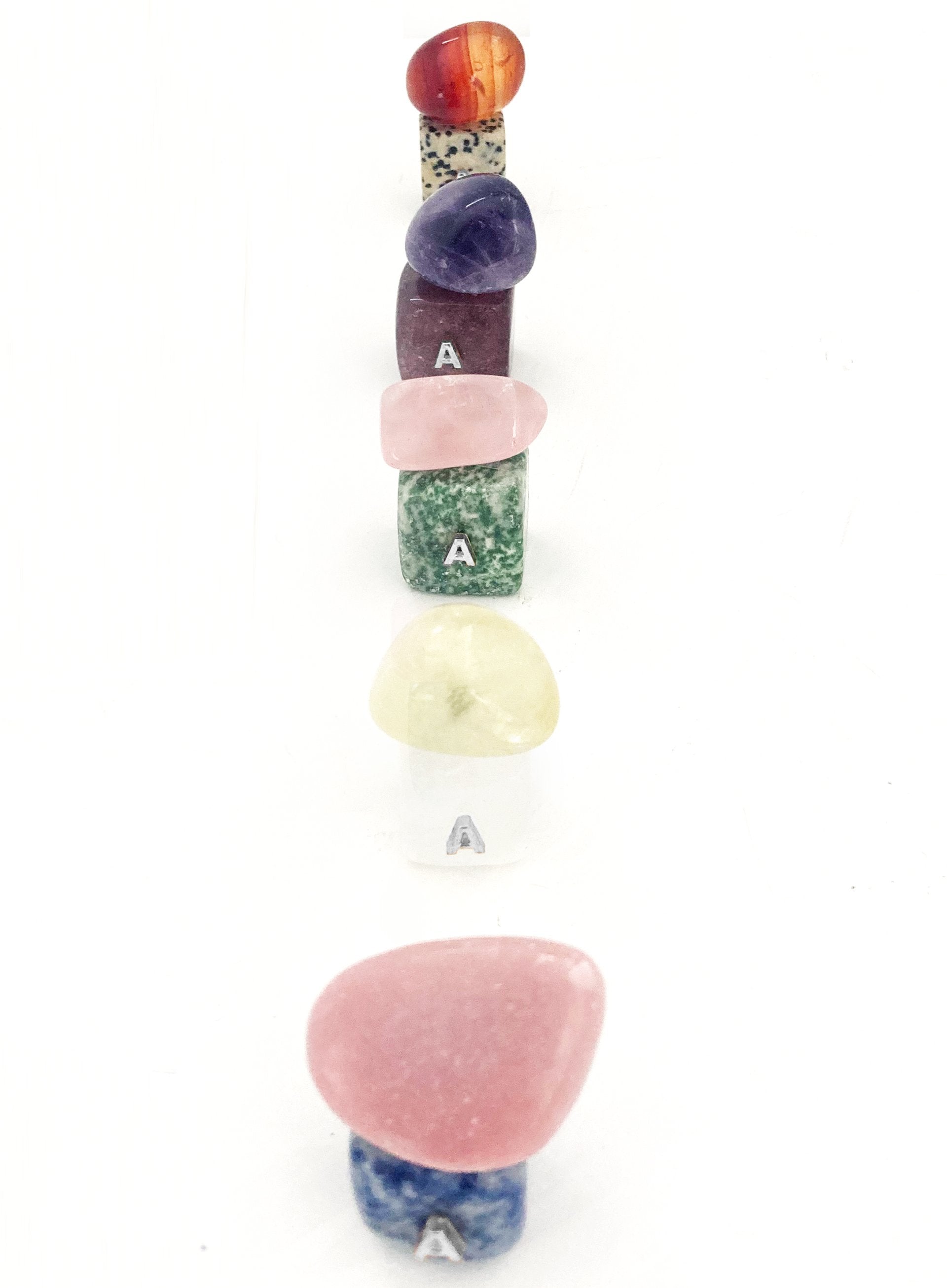 Set of colorful stone-shaped letter 'A' charms on a white background