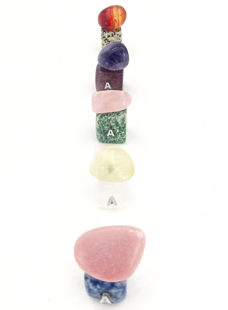 Set of colorful stone-shaped letter 'A' charms on a white background