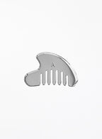 A polished silver metal hair comb with a small engraved letter 'A' on the front, shown against a plain white background.