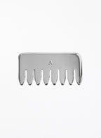 A silver metal hair-tooth comb with a small engraved letter 'A' in the center, shown against a plain white background.