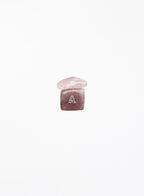 A small pink gemstone charm with a polished rounded top and a faceted square base engraved with the letter 'A', centered on a plain white background.