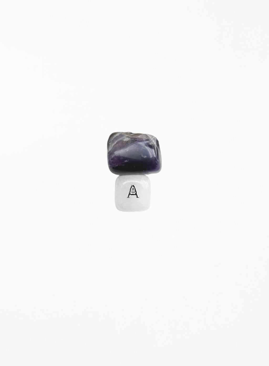 A small jewelry charm or bead featuring a polished dark purple and black stone on top of a white cube with a black letter 'A' printed on it, centered against a solid white background.