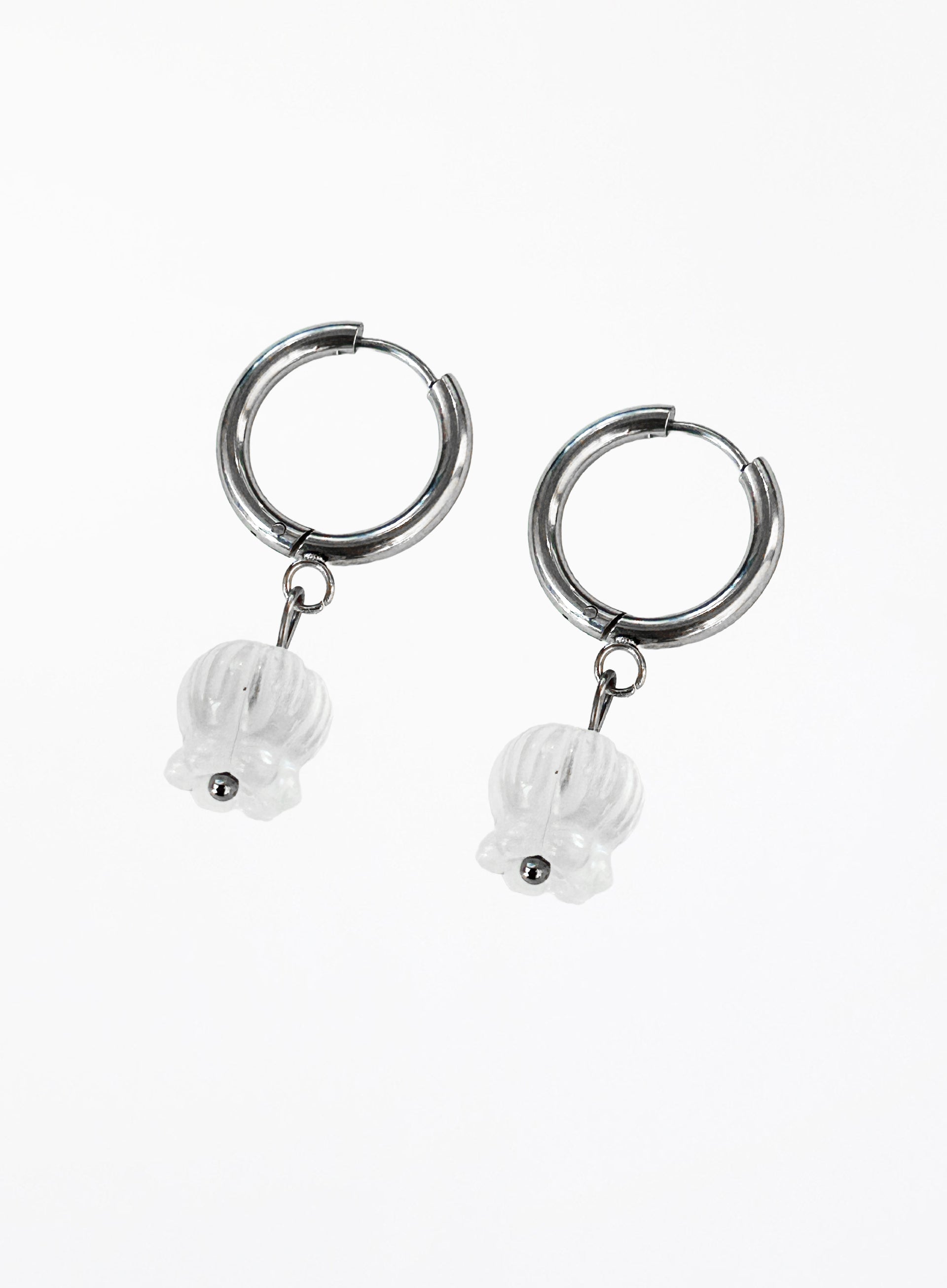 Silver hoop earrings with white stone charms on a white background