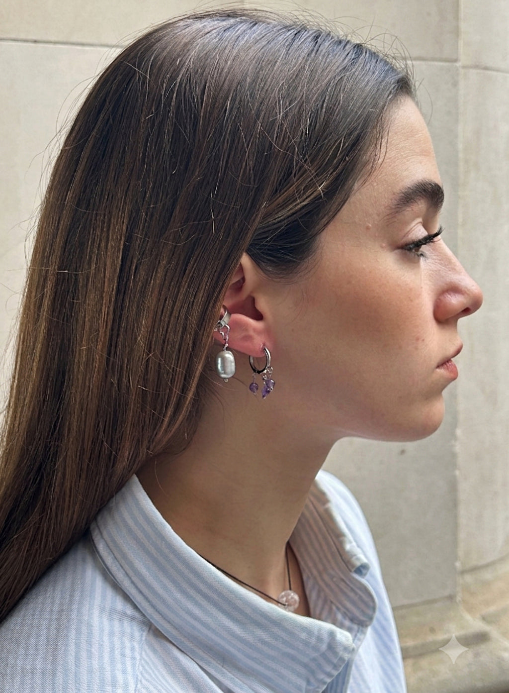 Woman wearing earrings with a neutral background