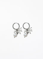 A pair of silver hoop earrings with dangling pearl clusters and small silver beads, shown on a plain white background.