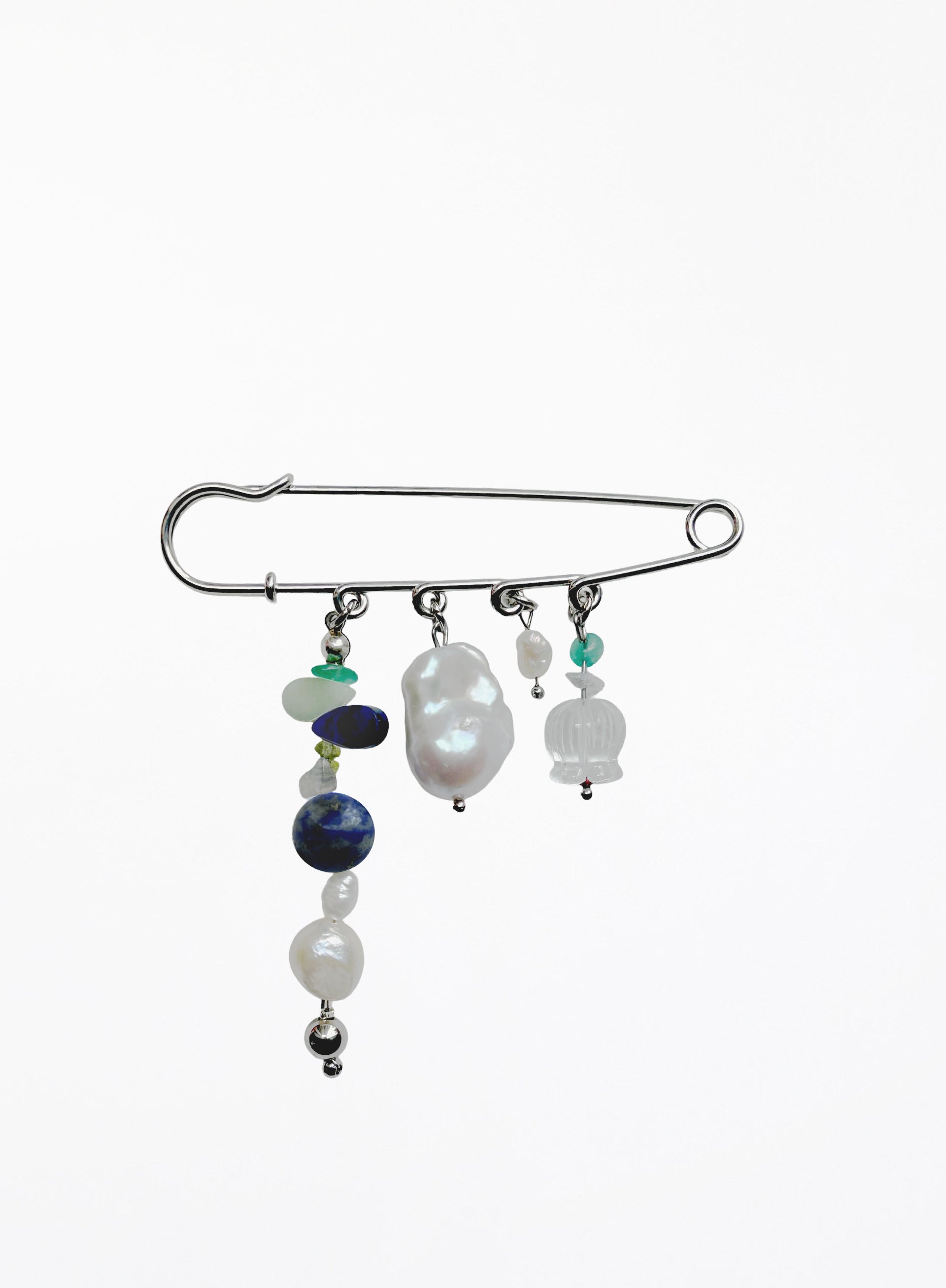 A silver safety pin styled as a hair claw clip, adorned with various beaded strands including white pearls, a dark blue bead, and small green and white stones, set against a plain white background.