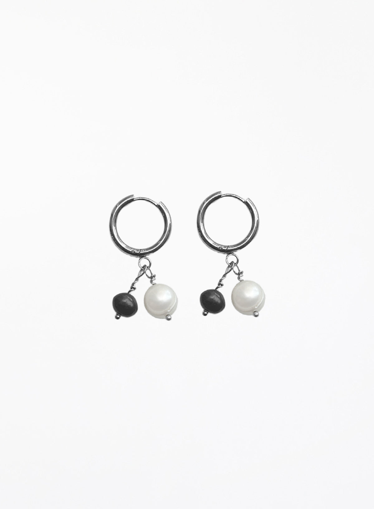 A pair of silver hoop earrings with dangling black beads and white pearl-like drops, shown on a plain white background.