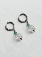 Pair of hoop earrings with clear glass beads and green gemstones on a white background