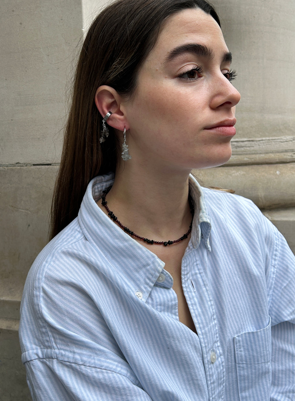woman in blue stripe shirt wearing abradorite dangle huggie earrings and earcuffs