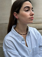 woman in blue stripe shirt wearing abradorite dangle huggie earrings and earcuffs
