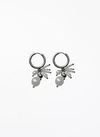 Pair of silver hoop earrings with pearl drops on a white background