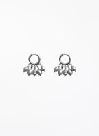 a pearl of grey pearl charms earrings in huggie hoop against white background