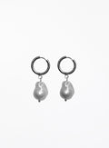Pair of hoop earrings with baroque pearl drops on a white background