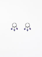 Pair of hoop earrings with purple beads on a white background