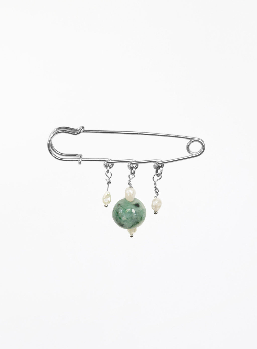A silver safety pin brooch with three dangling charms: a large green jade bead, a small cream pearl, and a tiny silver bead.