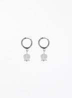 Pair of silver hoop earrings with white bulb-shaped charms on a white background