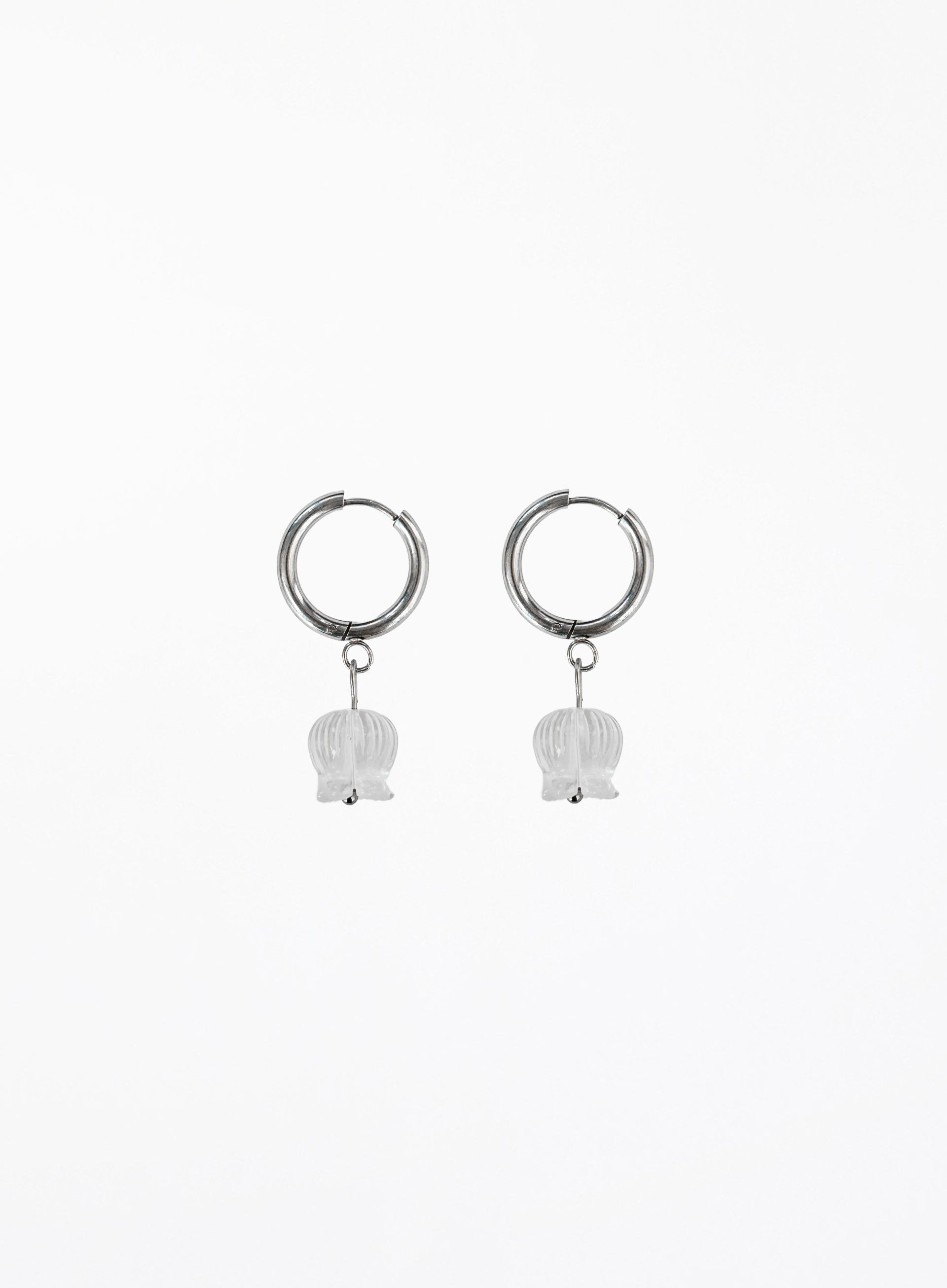 Pair of silver hoop earrings with white bulb-shaped charms on a white background
