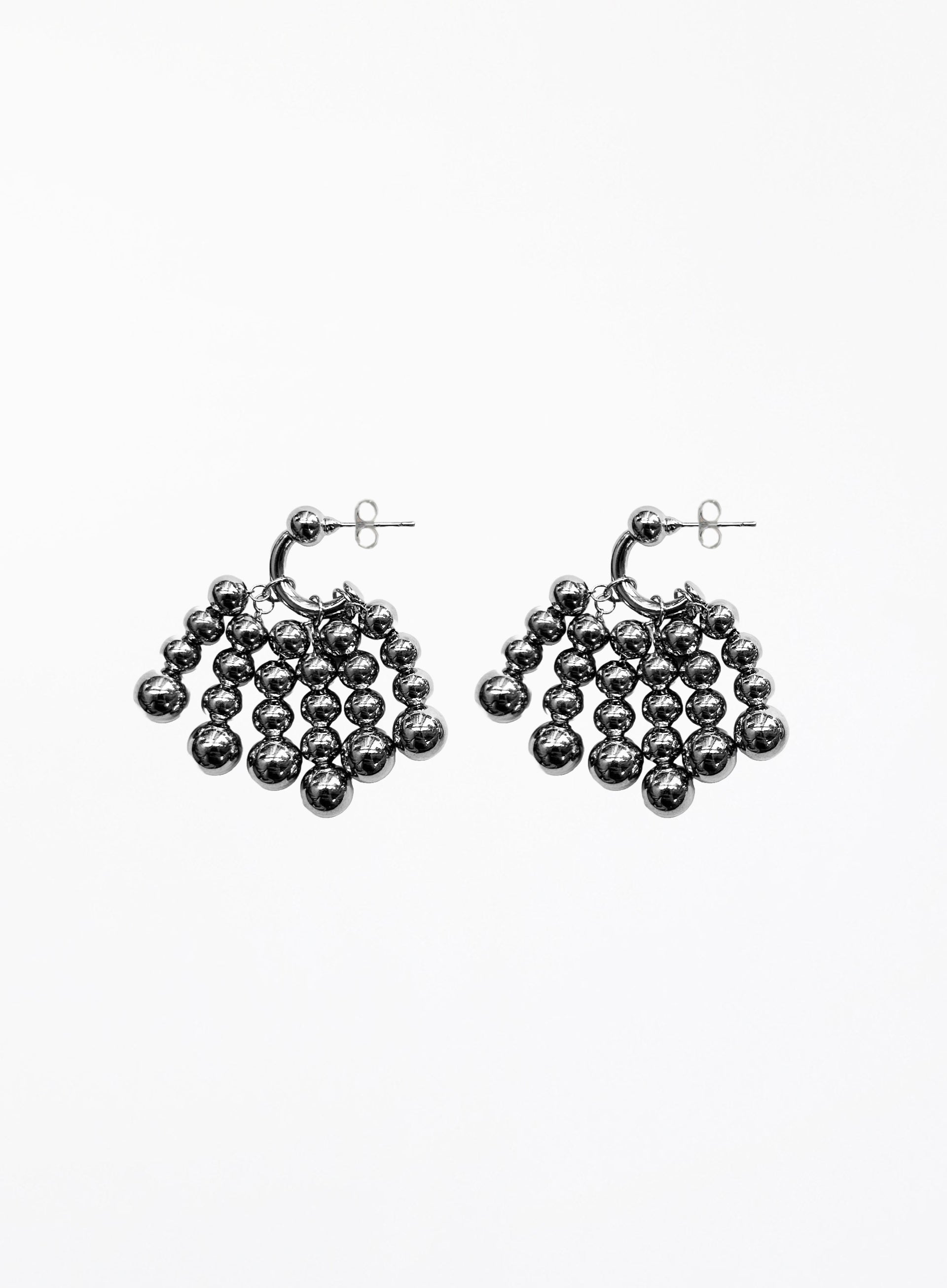 Pair of silver beaded hoop earrings on a white background