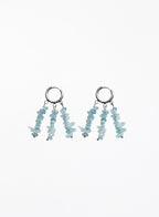 A pair of silver hoop dangle earrings with three strands of light blue chip stones hanging from each hoop, shown against a plain white background.