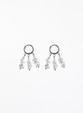 A pair of silver-toned dangle earrings featuring small clear faceted gemstone clusters hanging from open circular hoops, shown against a plain white background.
