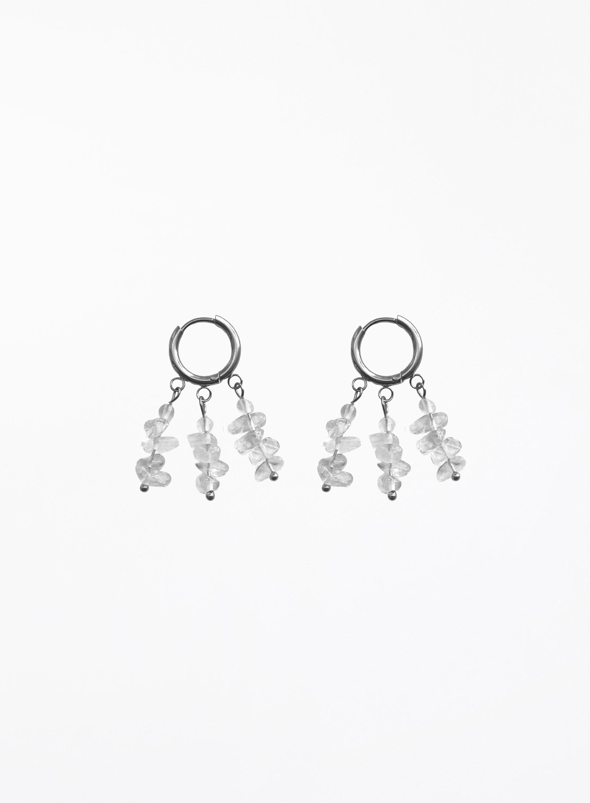 A pair of silver-toned dangle earrings featuring small clear faceted gemstone clusters hanging from open circular hoops, shown against a plain white background.