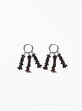 A pair of drop earrings featuring silver-tone hoop tops and dangling clusters of dark brown to black disc-shaped beads with small red accents, shown on a plain white background.