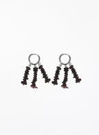 A pair of drop earrings featuring silver-tone hoop tops and dangling clusters of dark brown to black disc-shaped beads with small red accents, shown on a plain white background.
