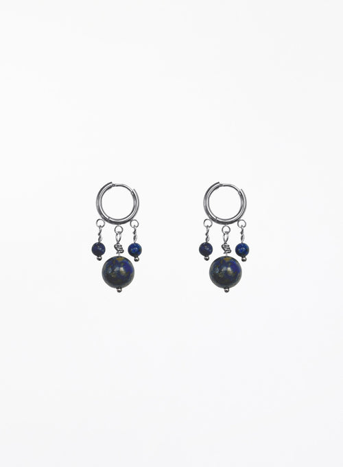 A pair of silver hoop earrings with dangling blue beads and dark round stones, shown against a plain white background.
