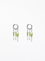 A pair of silver hoop dangle earrings with small green and white beads, shown on a plain white background.