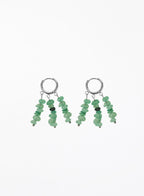 A pair of silver hoop earrings with dangling chains of small green stone beads, shown on a plain white background.