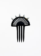 A black resin fan-shaped hair comb with five prongs and five small white decorative pearls on the top, shown against a plain white background.