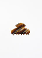 Brown hair clip with marbled pattern on a white background