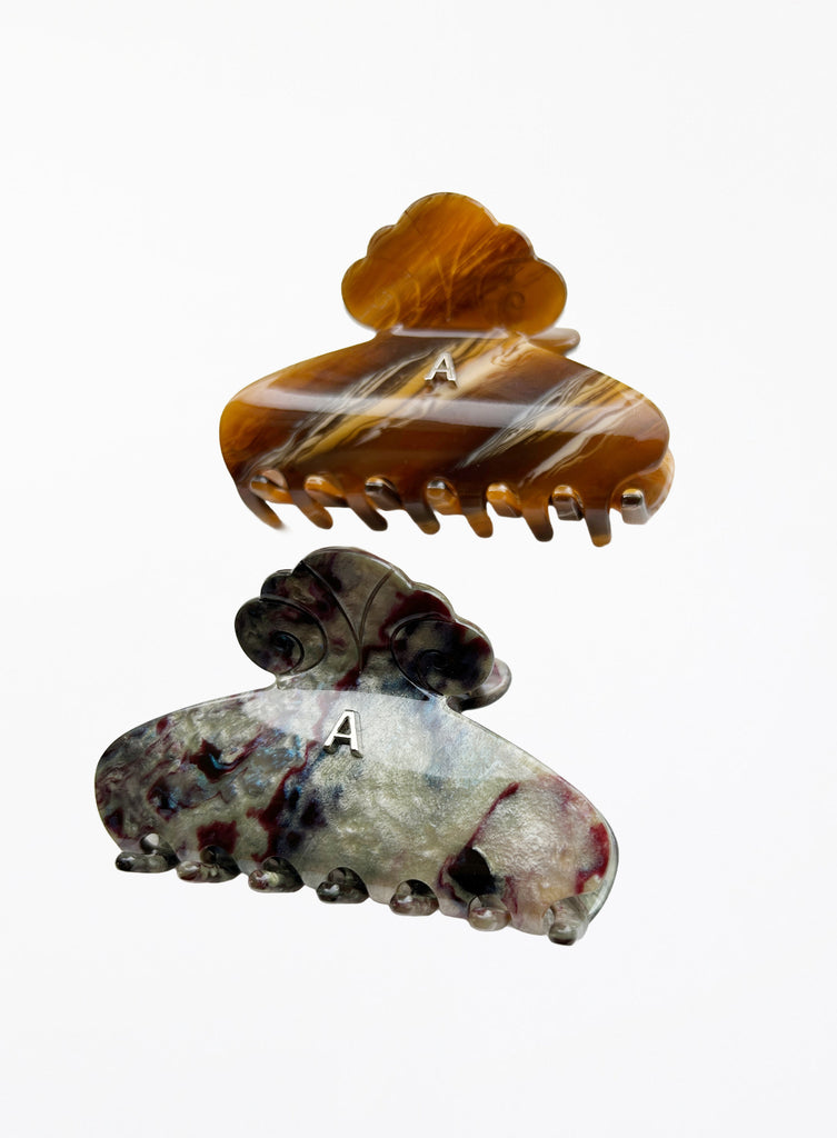 Two decorative hair clips with marbled patterns on a white background