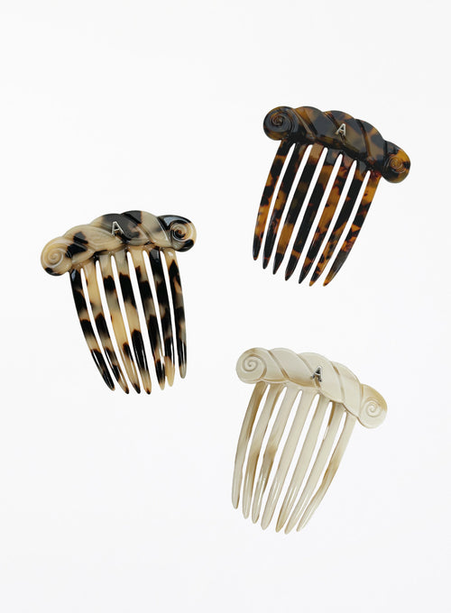 Three tortoiseshell and cream-colored hair combs on a white background