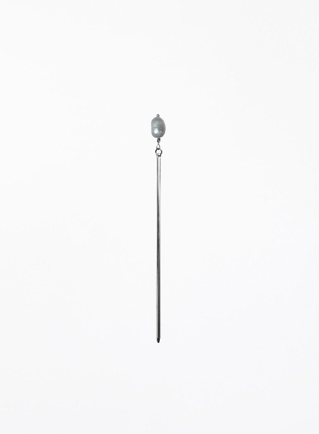 A long, minimalist hairpin featuring a single teardrop-shaped light gray pearl suspended from a very thin, polished silver-toned metal rod, set against a solid white background.