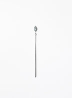 A long, minimalist hairpin featuring a single teardrop-shaped light gray pearl suspended from a very thin, polished silver-toned metal rod, set against a solid white background.
