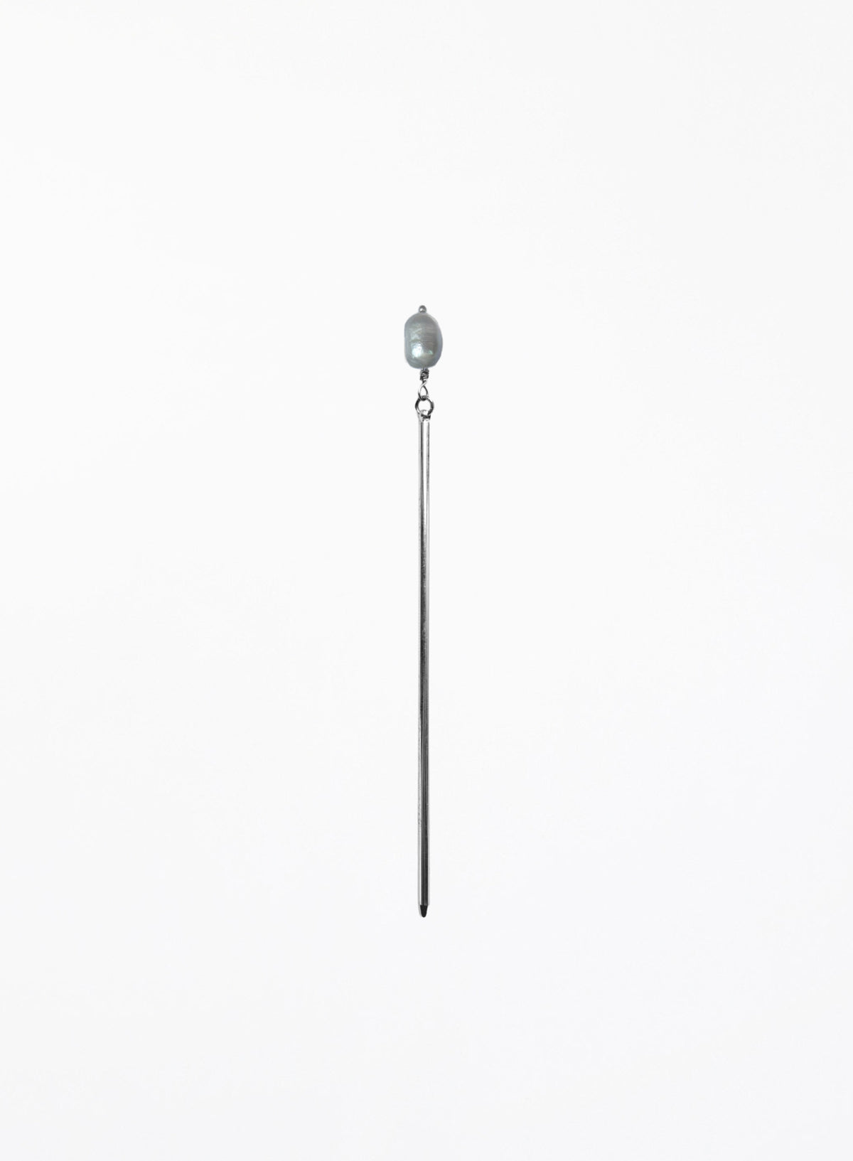 A long, minimalist hairpin featuring a single teardrop-shaped light gray pearl suspended from a very thin, polished silver-toned metal rod, set against a solid white background.