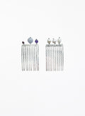 A pair of silver-toned long hair combs with twisted vertical prongs, decorated with small decorative beads at the top, shown on a plain white background.