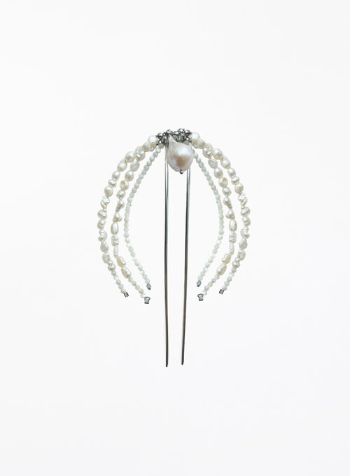 A pearl hair accessory with multiple strands of white freshwater pearls draped over a silver metal hair stick, featuring a central pearl