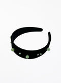Black headband with green beads on a white background