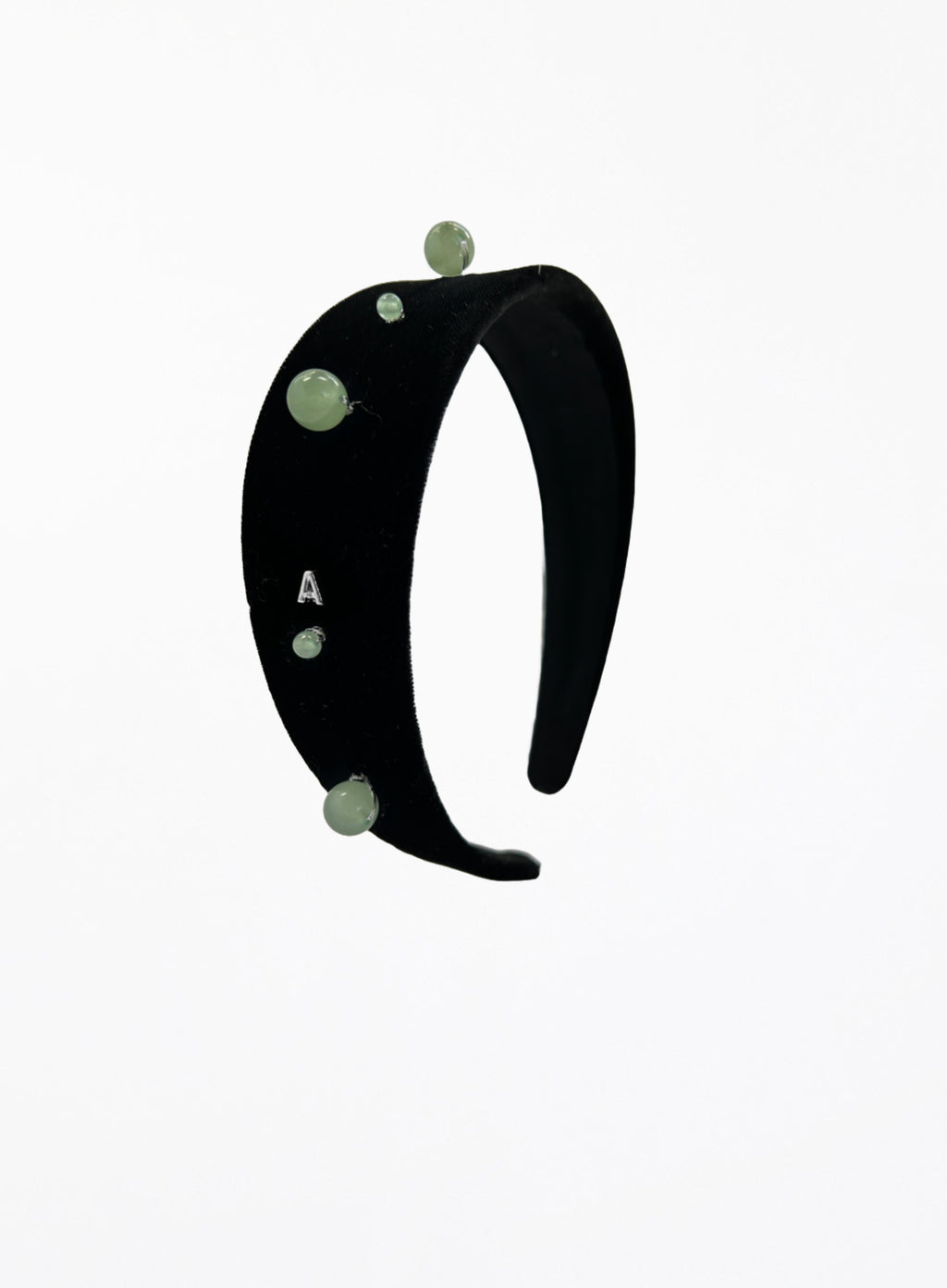 Black headband with green beads on a white background