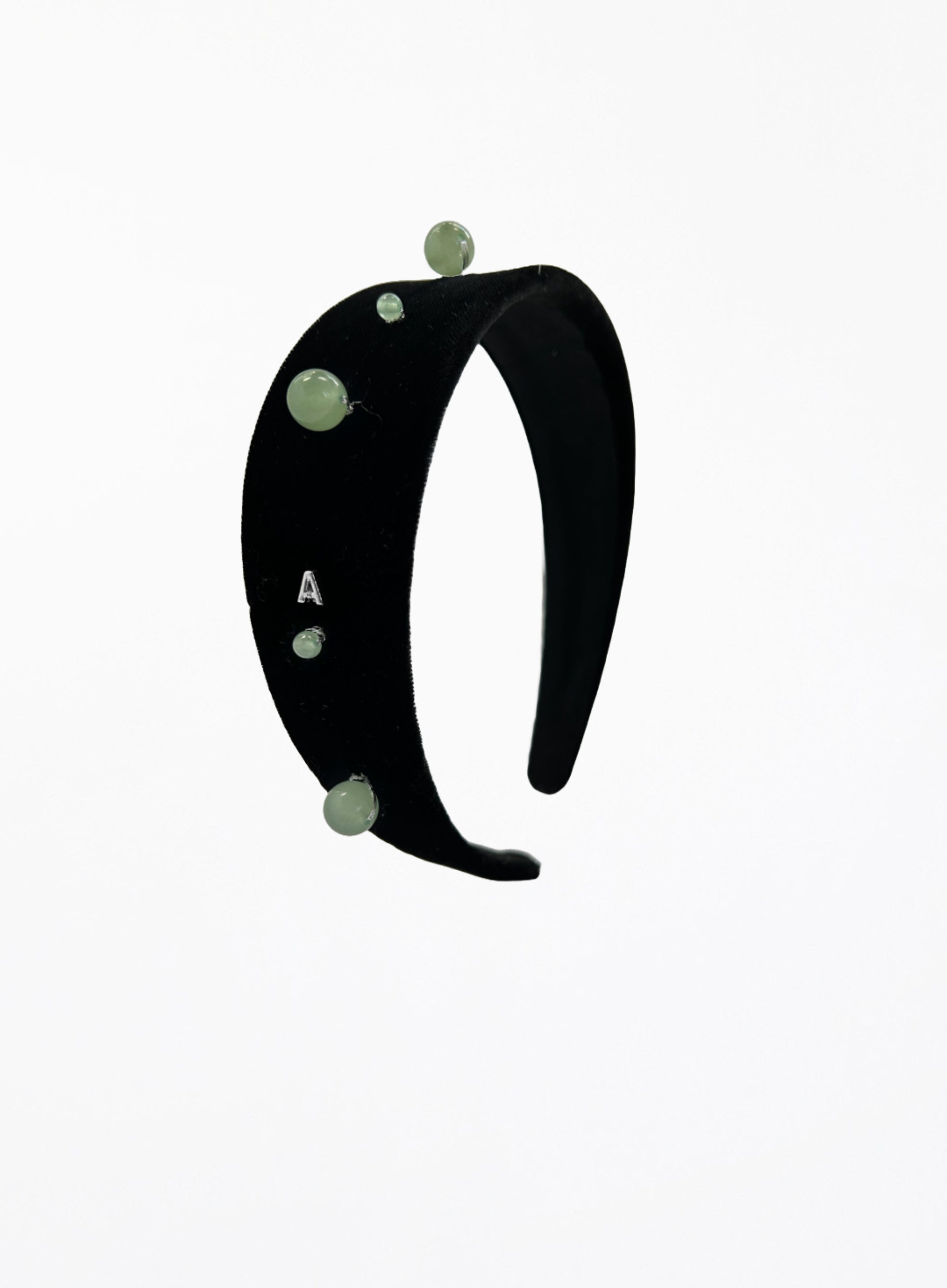 Black headband with green beads on a white background