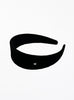 Black headband with a small silver logo on a white background