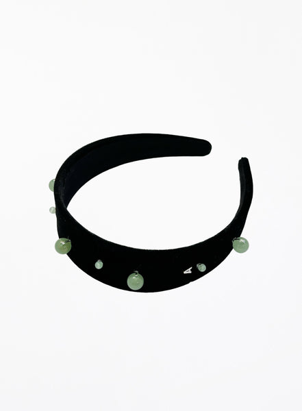 Black headband with green beads on a white background