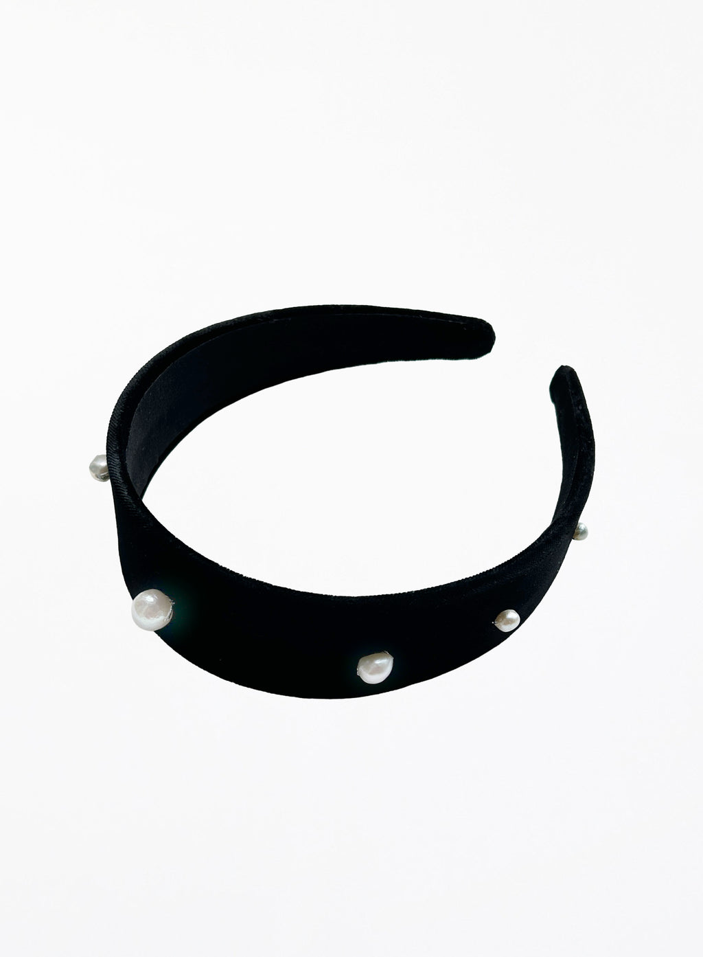 A wide black velvet headband decorated with small white pearl beads, shown against a plain white background.
