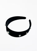 A wide black velvet headband decorated with small white pearl beads, shown against a plain white background.