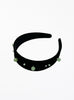 Black headband with green beads on a white background